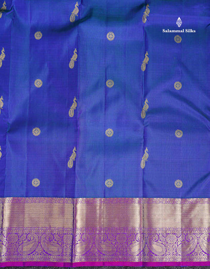 Pure Kanjivaram Silk Saree - Dual Tone Peacock Blue Chakaram & Peacock Butta Along With Contrast Dual Tone Purple Traditional Evening Morning Border